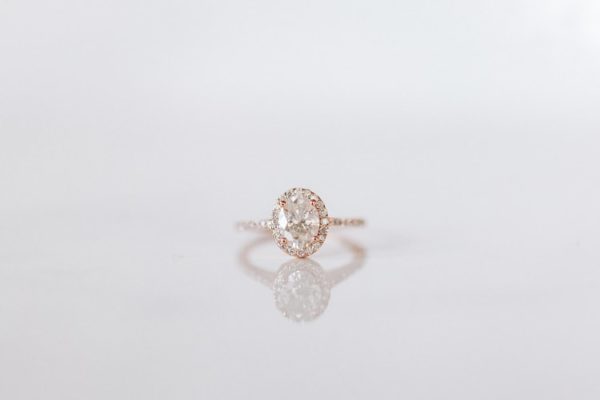 rose gold engagement band with oval cut diamond and halo setting