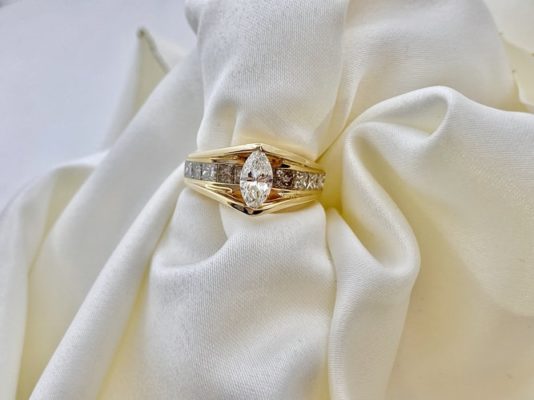 gold engagement ring with marquise cut diamond and pave setting