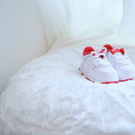 White baby shoes on a cushion
