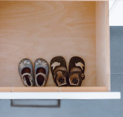 Two pairs of baby shoes in a drawer