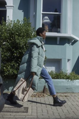 Woman wearing jacketv and jeans walking on a street